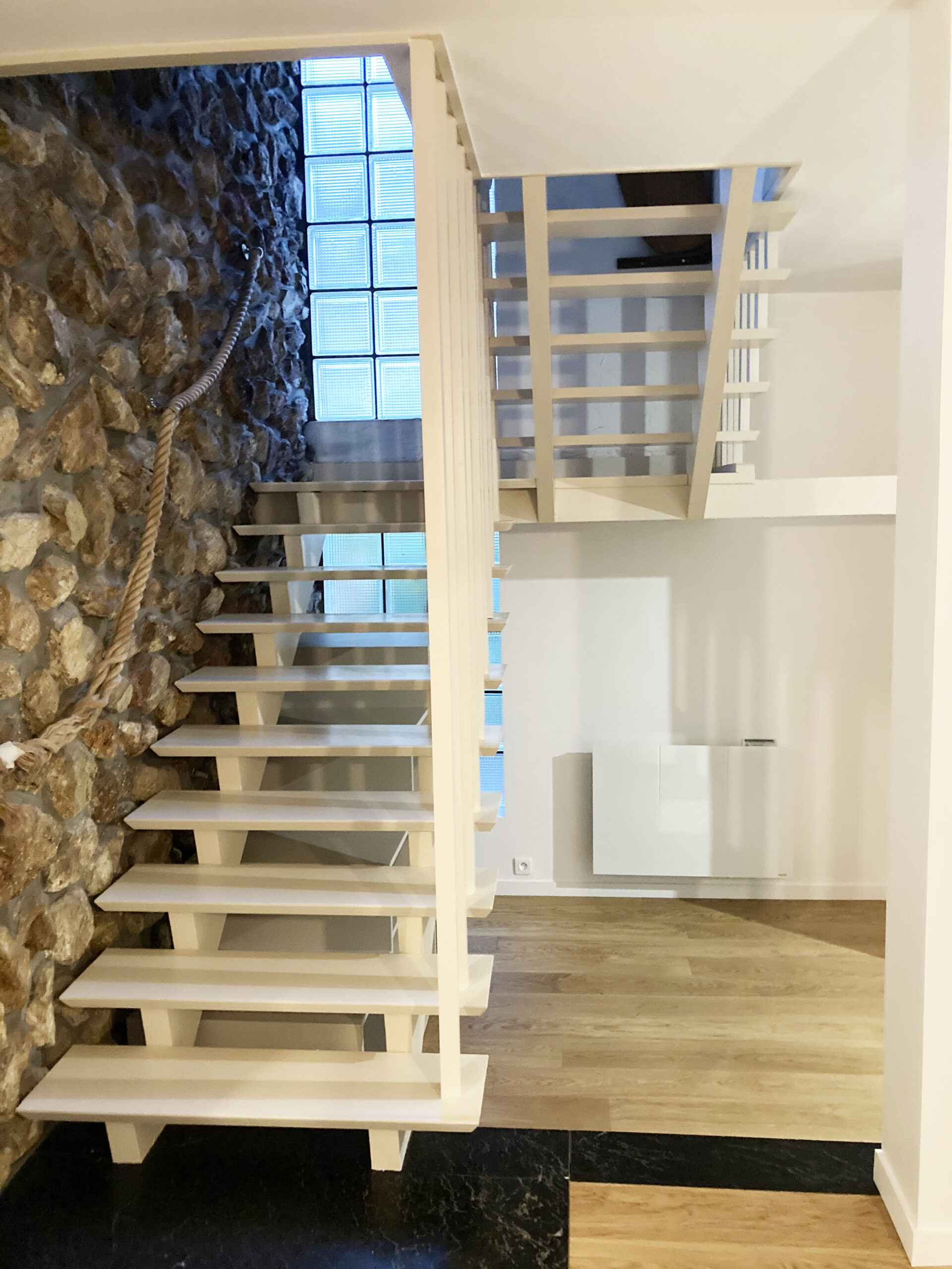 Rénovation intérieure et extérieure 45 77 91 94 - projet MG BATIMENT. Escalier rénové bois clair avec mur en pierre et lumière naturelle.