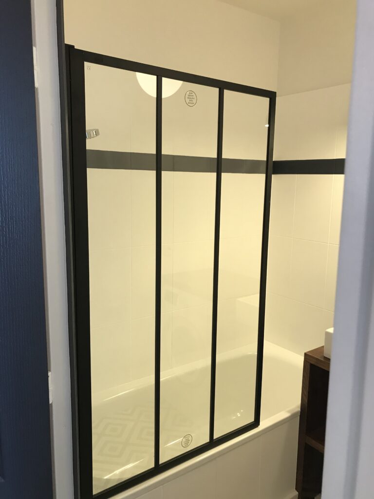 Baignoire rénovée avec pare-bain verrière noire style atelier