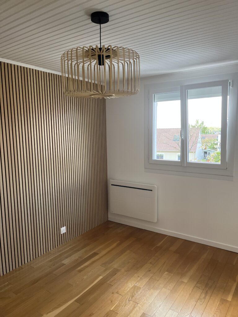 Chambre rénovée avec parquet bois et luminaire moderne