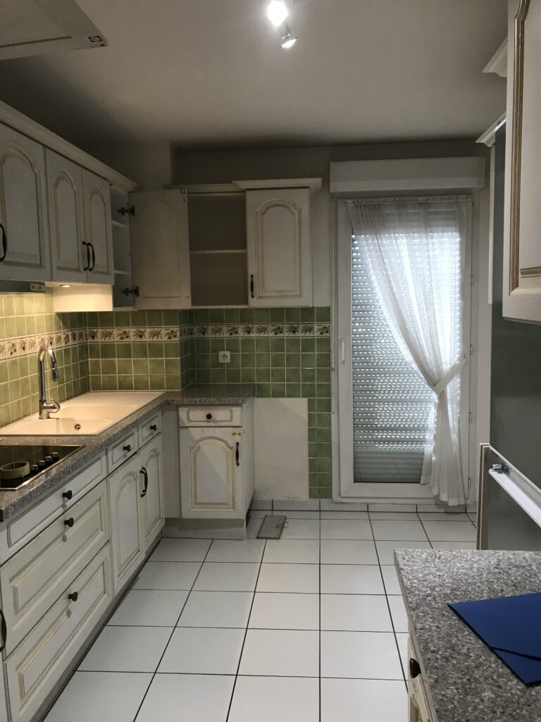 Ancienne cuisine avec carrelage blanc et meubles rustiques