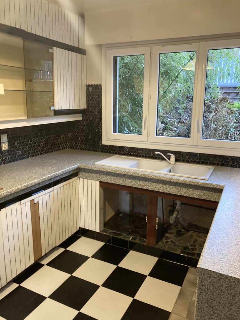 Cuisine ancienne avec carrelage damier noir et blanc