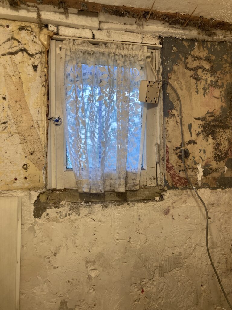 Ancienne fenêtre sur mur abîmé avant rénovation