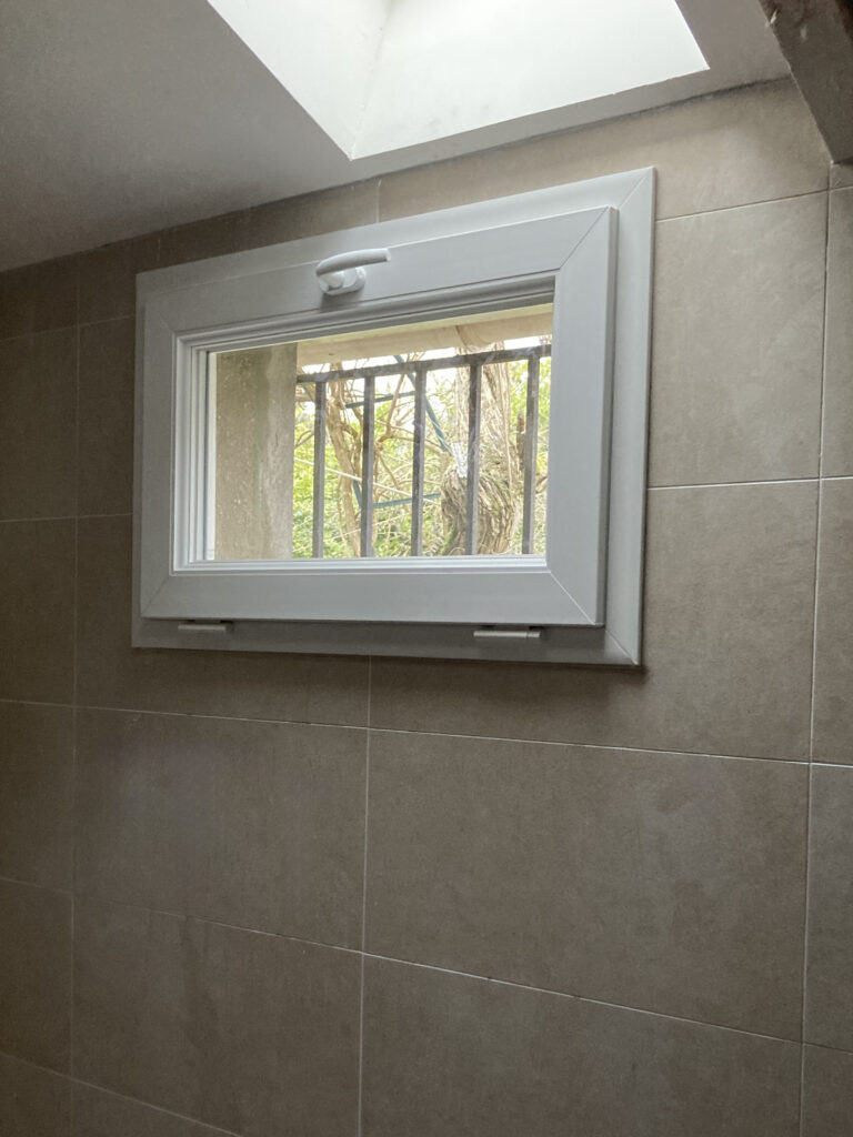 Fenêtre installée dans une pièce mansardée carrelée