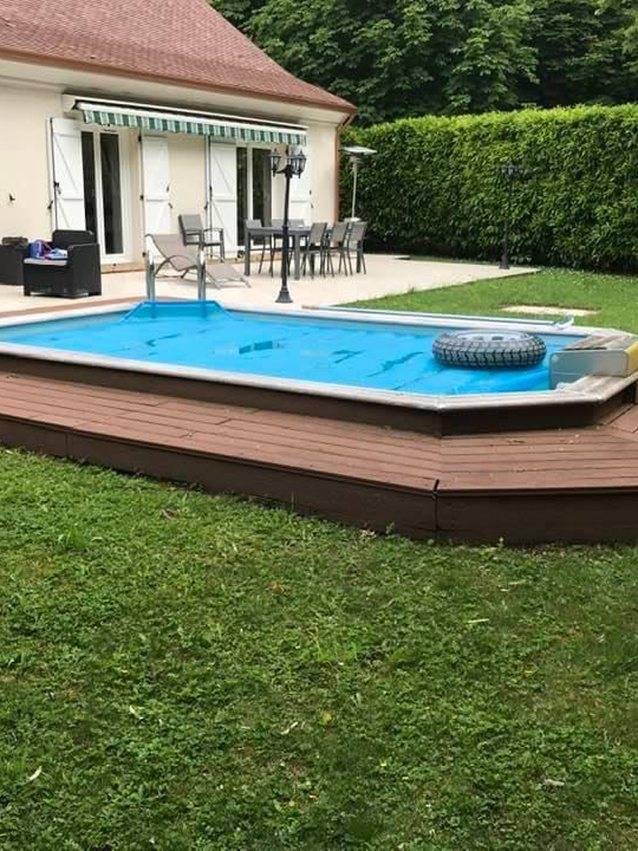 Piscine semi-enterrée avec habillage bois dans un jardin