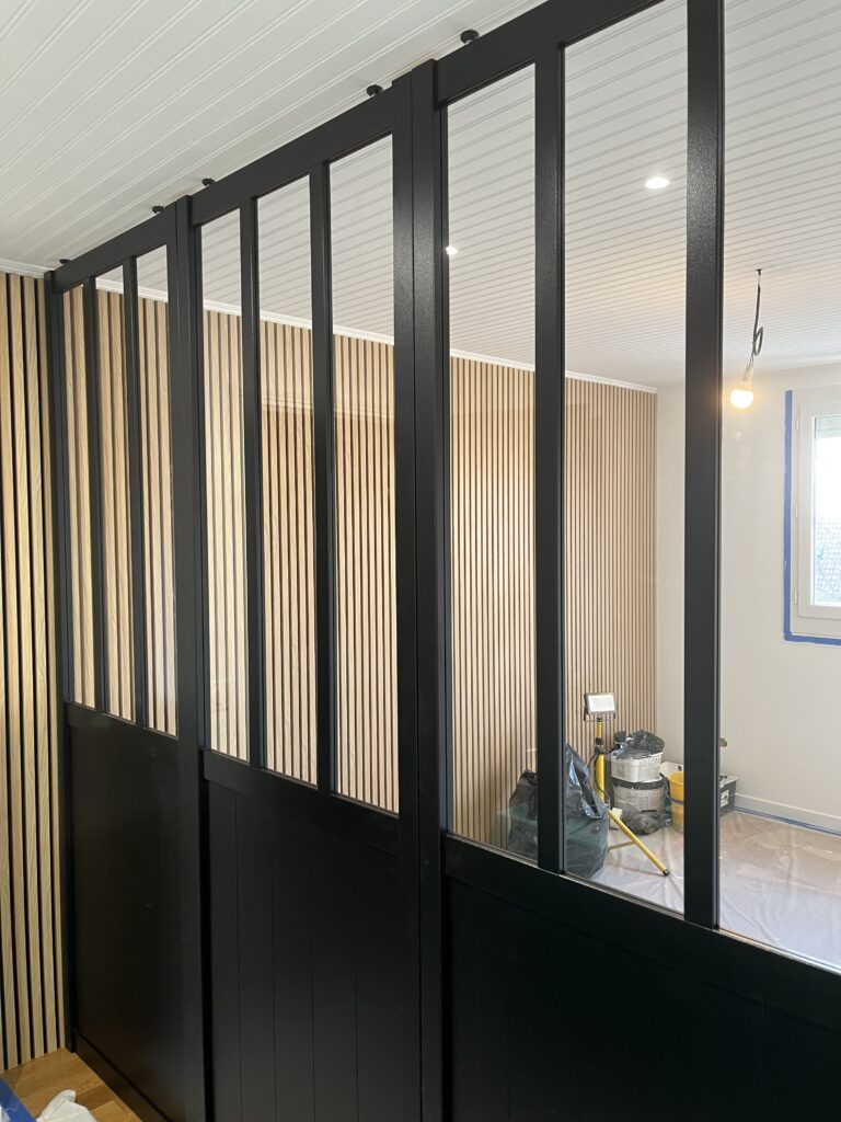 Verrière noire dans une chambre boisée rénovée