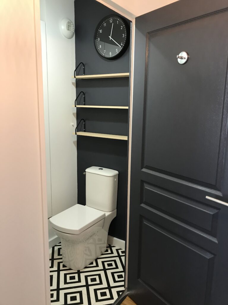 WC rénovés avec sol géométrique et murs gris foncé